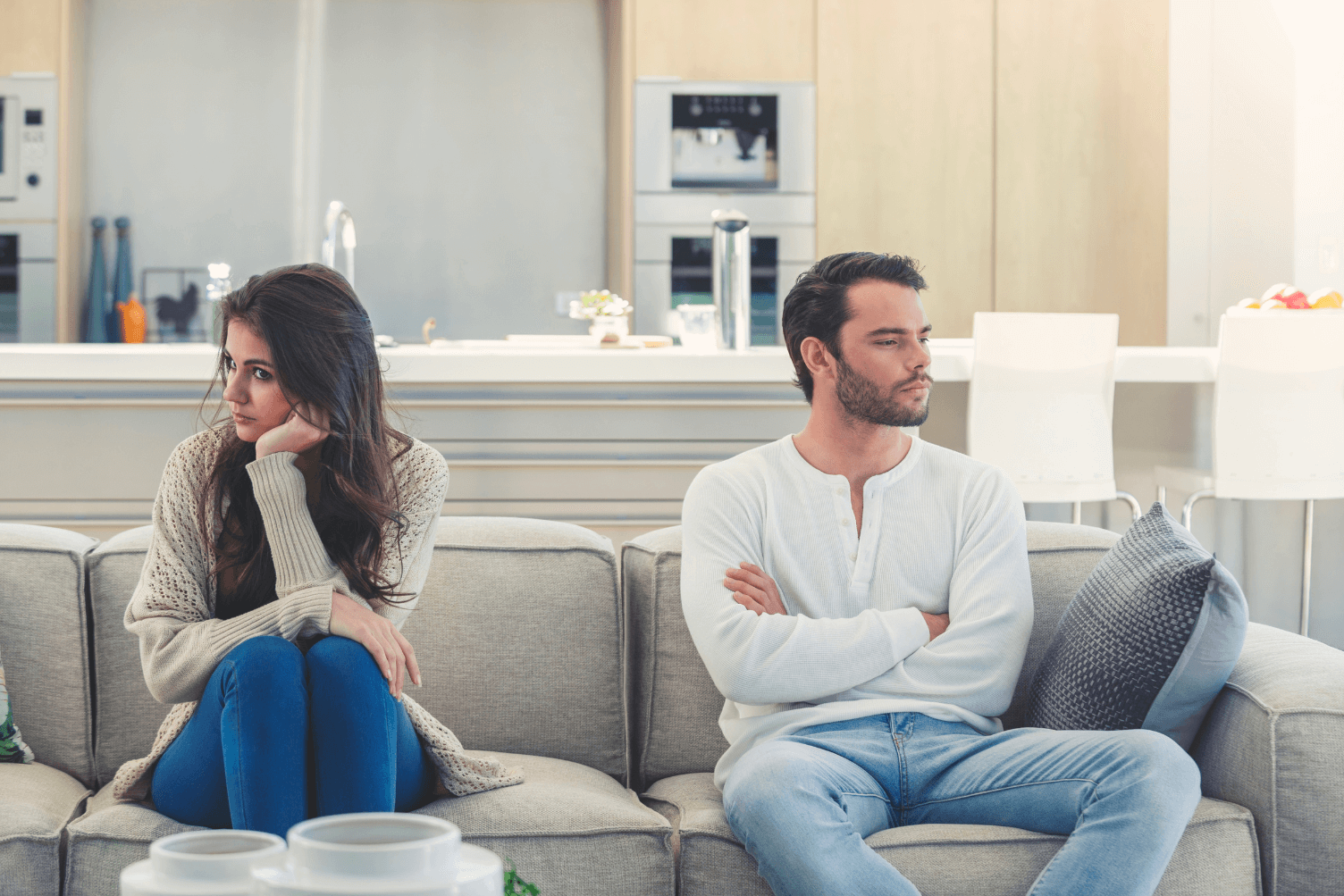 woman feeling blamed by her husband sitting apart on couch